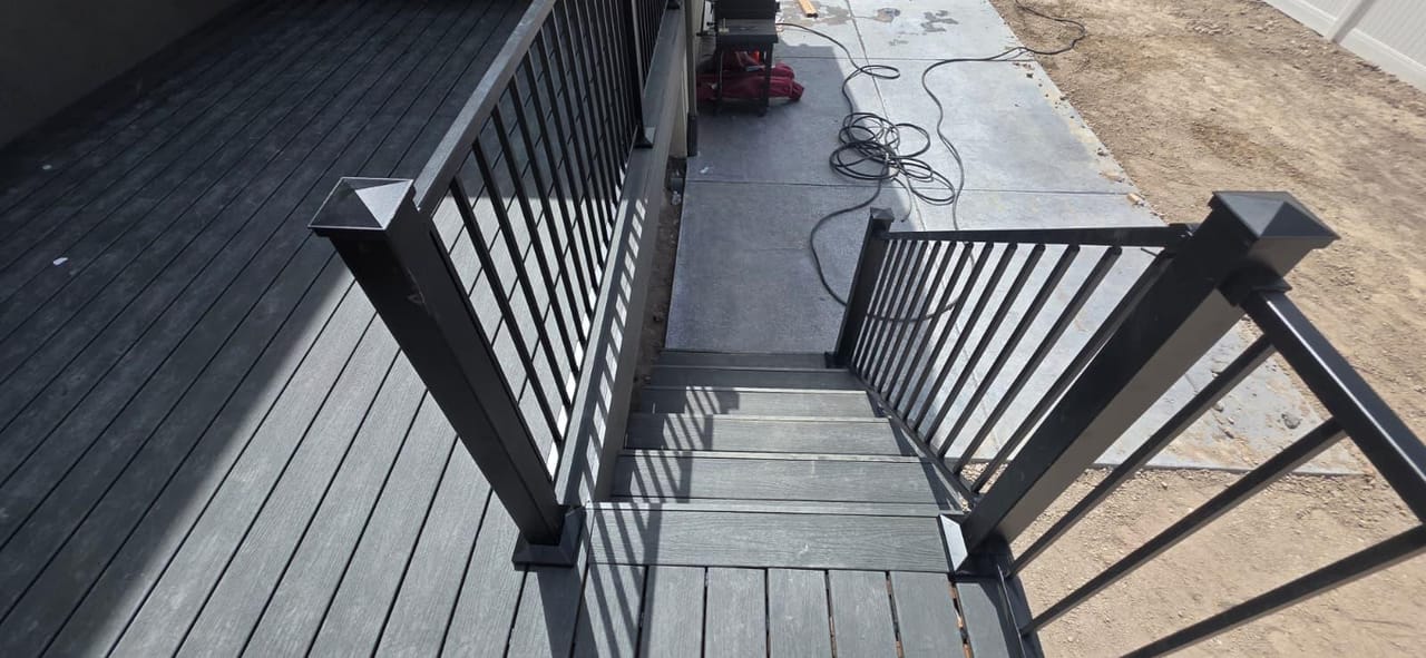 Detalle de escalones de deck de composite oscuro con barandal de metal negro — detalle de escalera de deck en Utah por CasaMás Construction