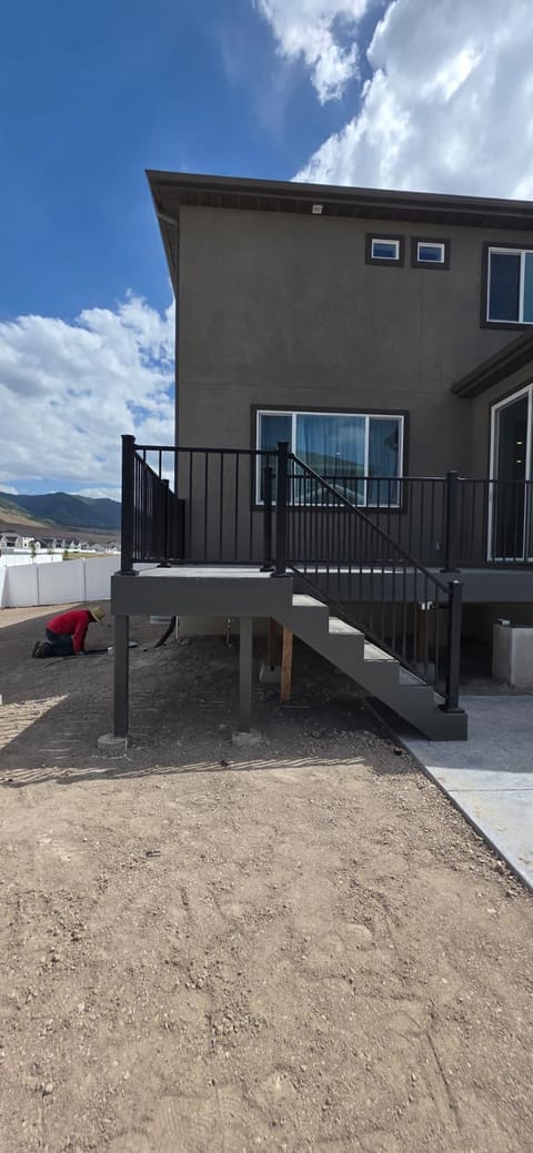 Mismo deck de composite desde un ángulo lateral mostrando escaleras, postes de soporte y montañas de Utah al fondo — por CasaMás Construction