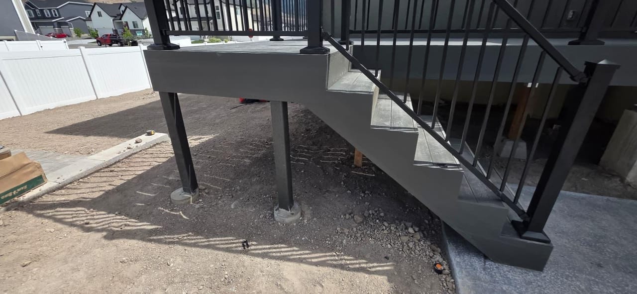 Mismo deck de dos pisos desde otro ángulo mostrando la escalera completa de conexión — por CasaMás Construction